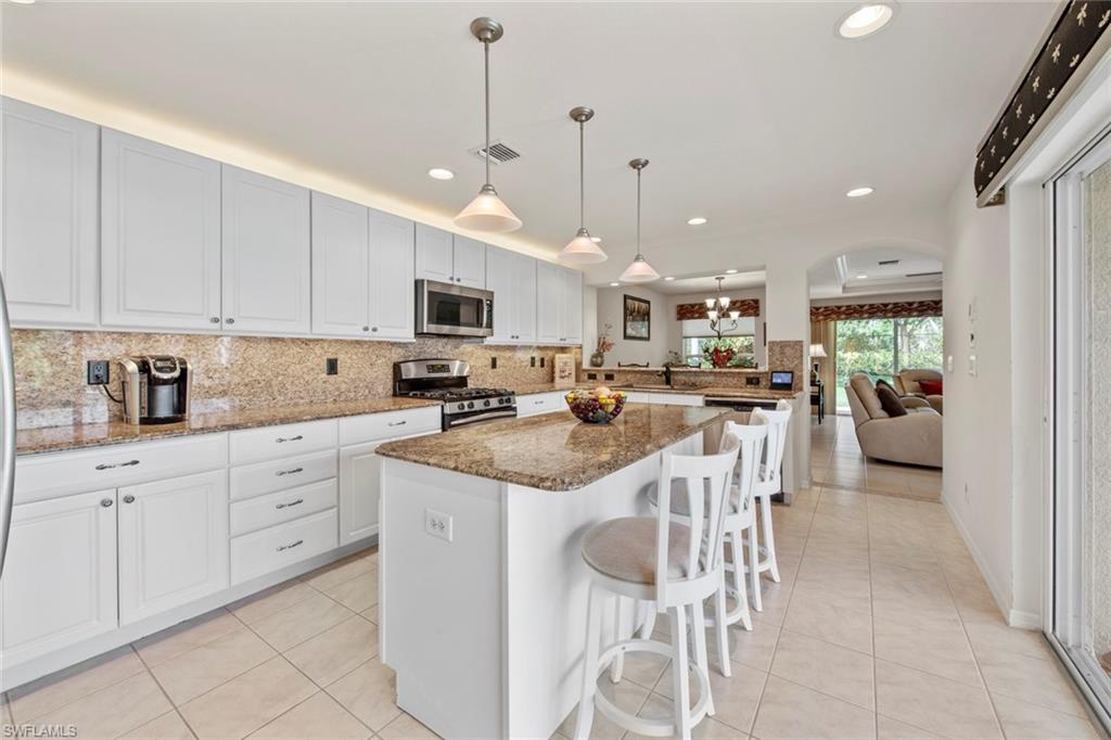 9046 Astonia Way Estero, FL 33967 - Photo 23 of 47 a kitchen with stainless steel appliances kitchen island granite countertop a sink and cabinets