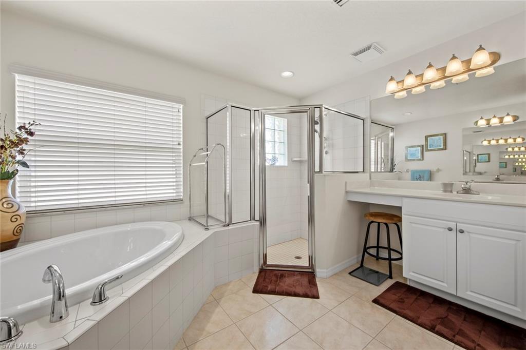 9046 Astonia Way Estero, FL 33967 - Photo 27 of 47 a spacious bathroom with a tub sink and mirror