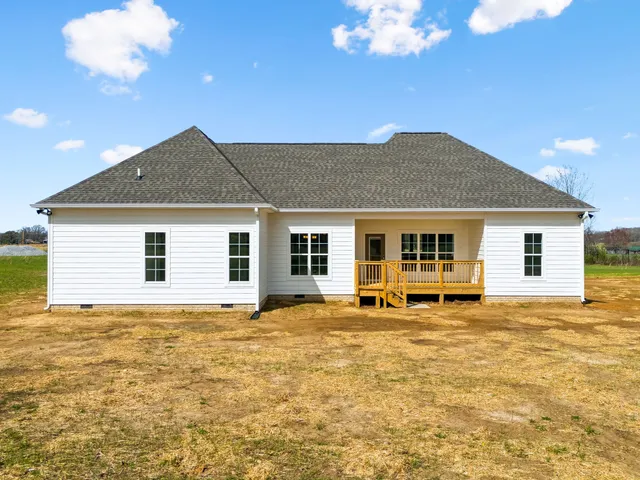 a sign that is sitting on a lush green field near a lake