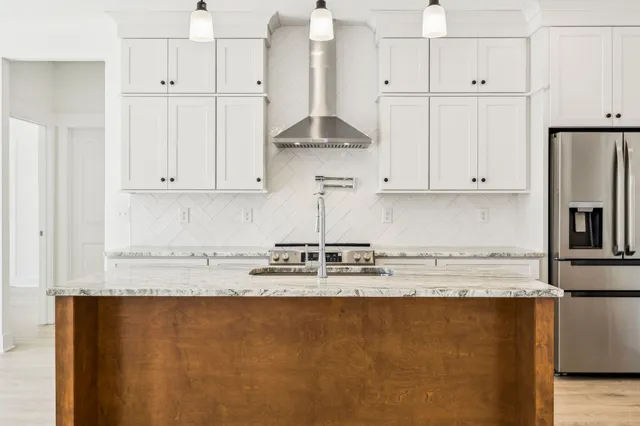 a kitchen with stainless steel appliances granite countertop white cabinets and a granite counter tops