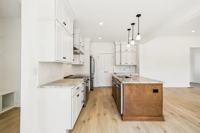 a kitchen with stainless steel appliances granite countertop a stove and a refrigerator