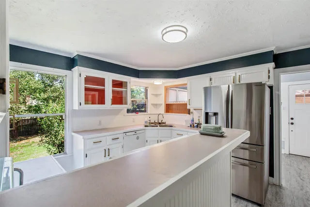 a kitchen with stainless steel appliances granite countertop a refrigerator and a sink