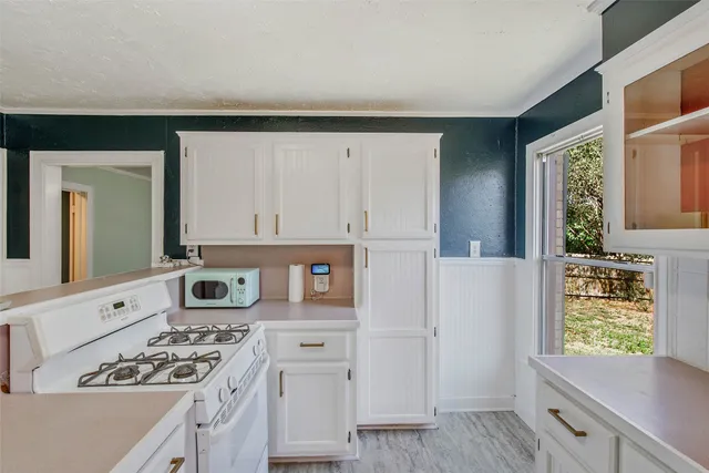 a kitchen with cabinets appliances a sink and a window