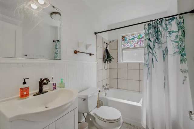 a bathroom with a sink a toilet and a shower curtain