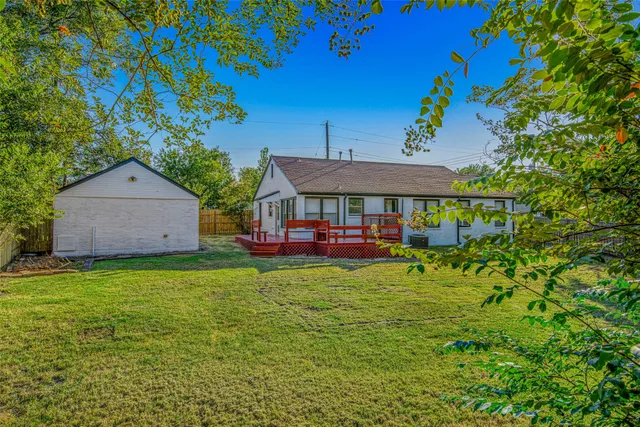 a view of house with garden space and sitting area