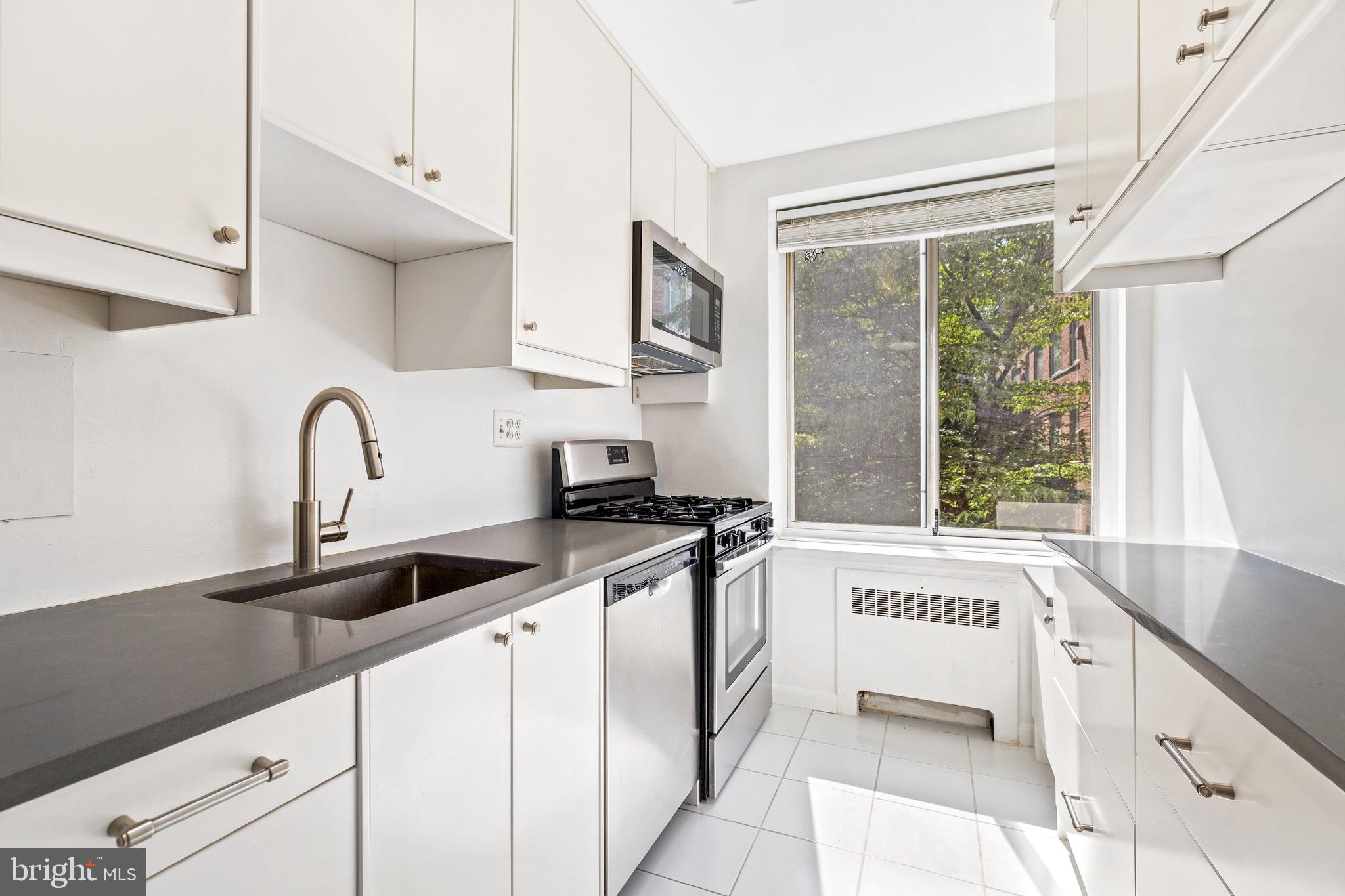 4100 W Street Northwest, Unit 306 Washington, DC 20007 - Photo 7 of 23 a kitchen with stainless steel appliances a sink a stove and a window
