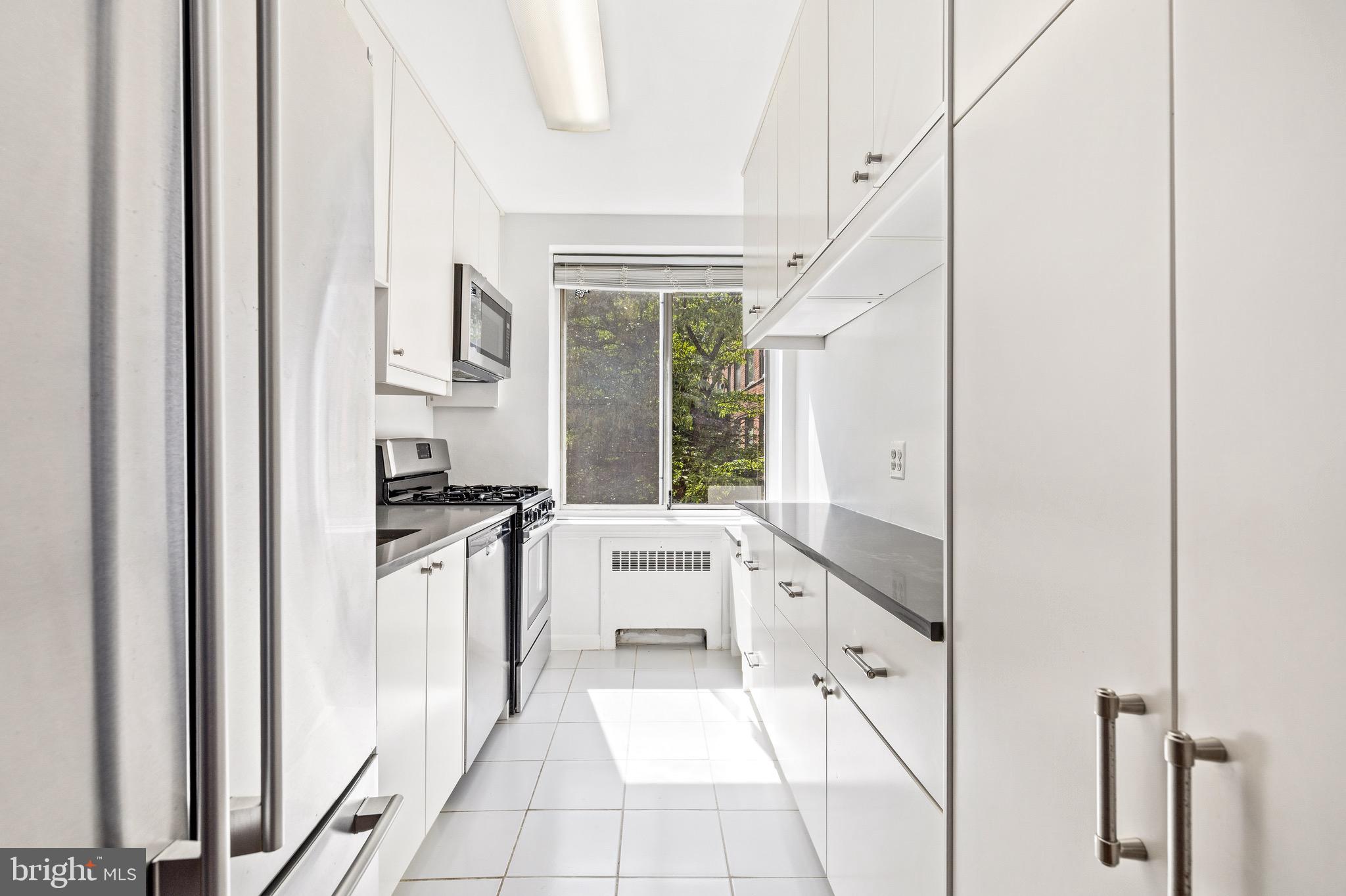 4100 W Street Northwest, Unit 306 Washington, DC 20007 - Photo 8 of 23 a kitchen with stainless steel appliances granite countertop a refrigerator and a sink
