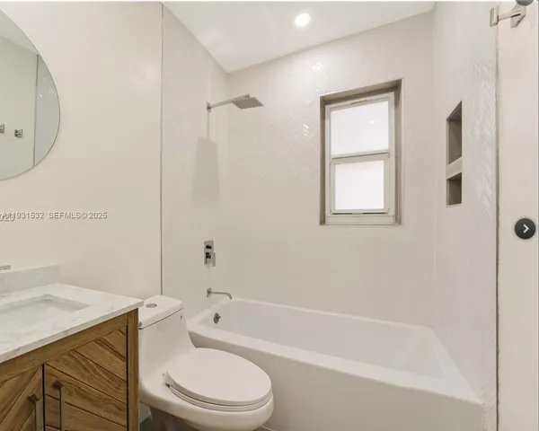a bathroom with a granite countertop toilet a sink and a bathtub