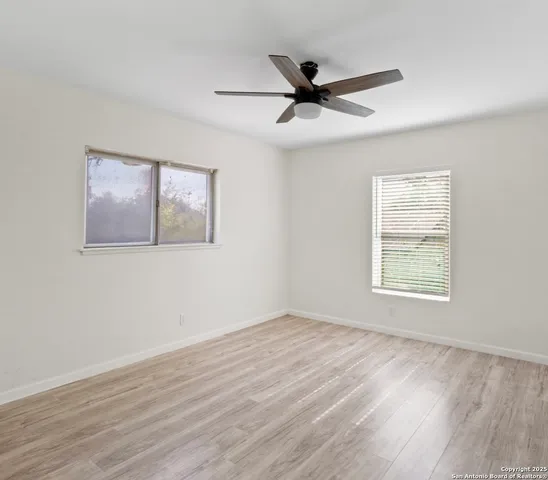 a view of a big room with wooden floor and windows