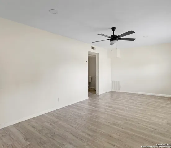a view of an empty room with wooden floor