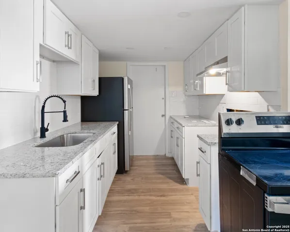 a kitchen with stainless steel appliances granite countertop a sink and dishwasher a stove with wooden floor