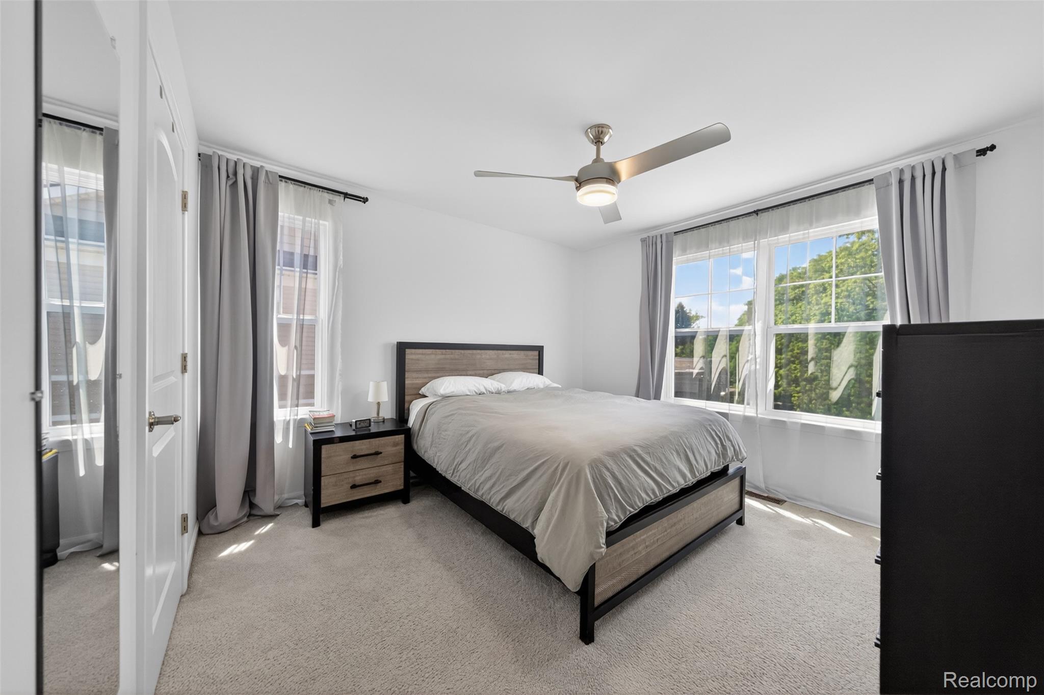 3534 South Rochester Road Royal Oak, MI 48073 - Photo 15 of 25 Carpeted bedroom featuring white walls, a ceiling fan with integrated lighting, and two large windows with sheer and opaque drapery