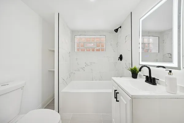 a bathroom with a sink a toilet and shower