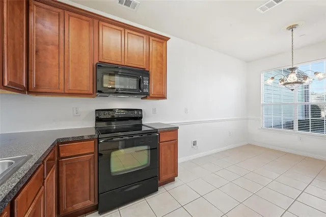 a kitchen with granite countertop a stove top oven cabinetry a sink and dishwasher