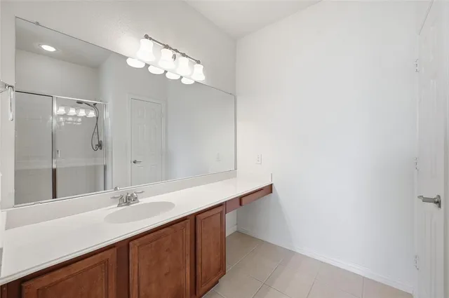 a bathroom with a sink a light fixture and a mirror