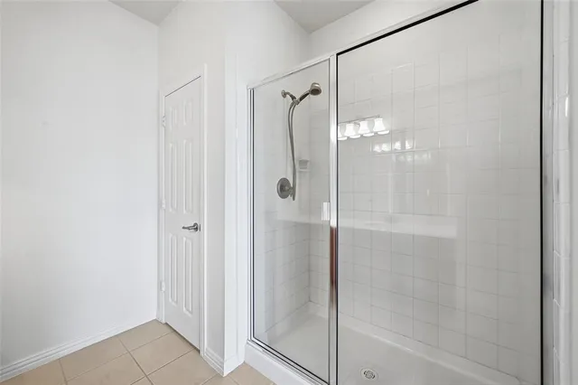 a bathroom with a glass shower door and a shower