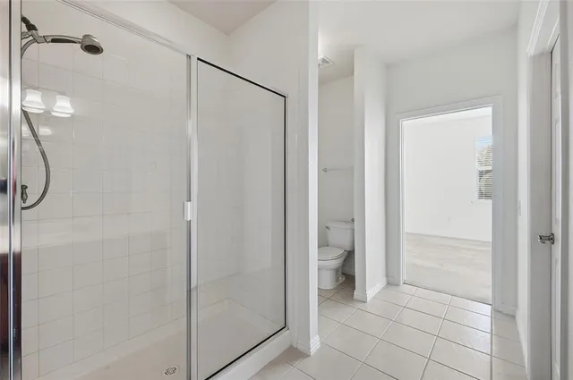 a bathroom with a shower and a glass door