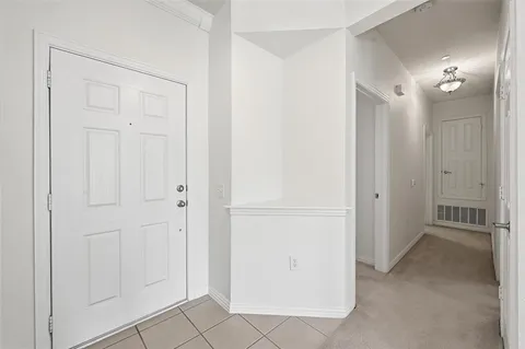 a view of a hallway with closet and a bathroom