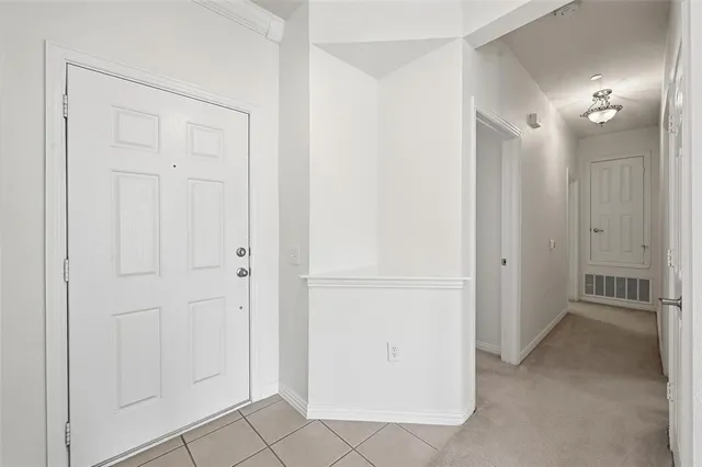 a view of a hallway with closet and a bathroom