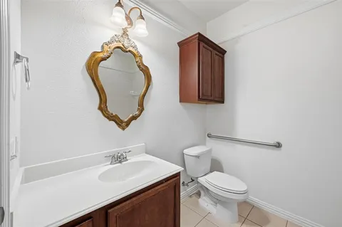 a bathroom with a toilet sink vanity and mirror