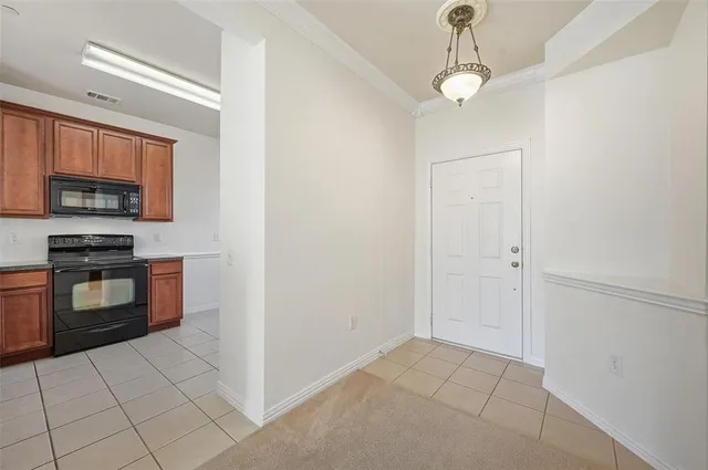 a kitchen with granite countertop a stove a microwave and a counter top space