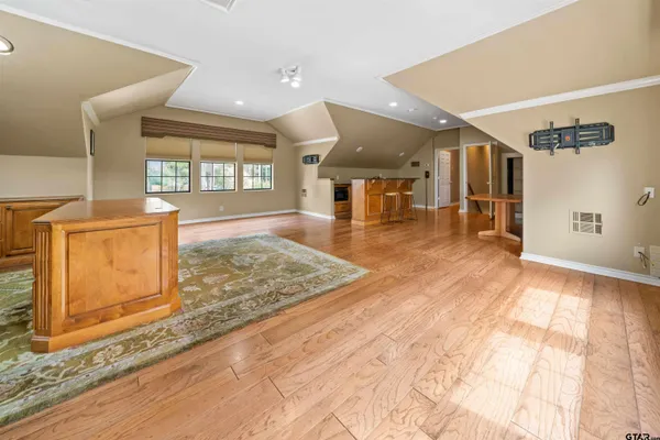 a view of a hall with wooden floor and a window