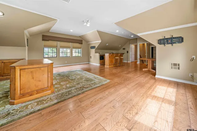 a view of a hall with wooden floor and a window