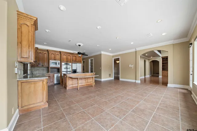 a view of a kitchen with kitchen island stainless steel appliances refrigerator sink and cabinets