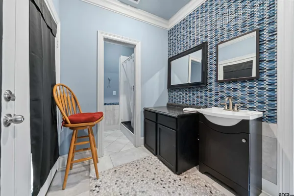 a bathroom with a sink a chair and a mirror