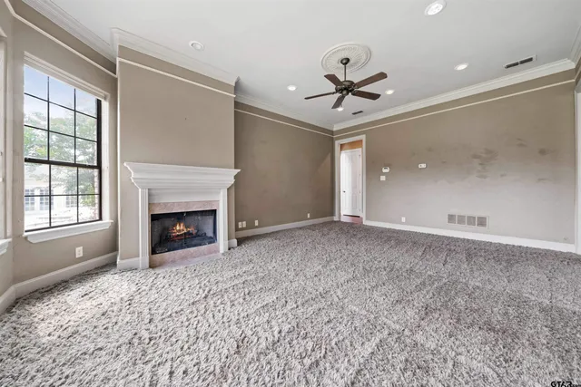 a view of empty room with a fireplace and fan