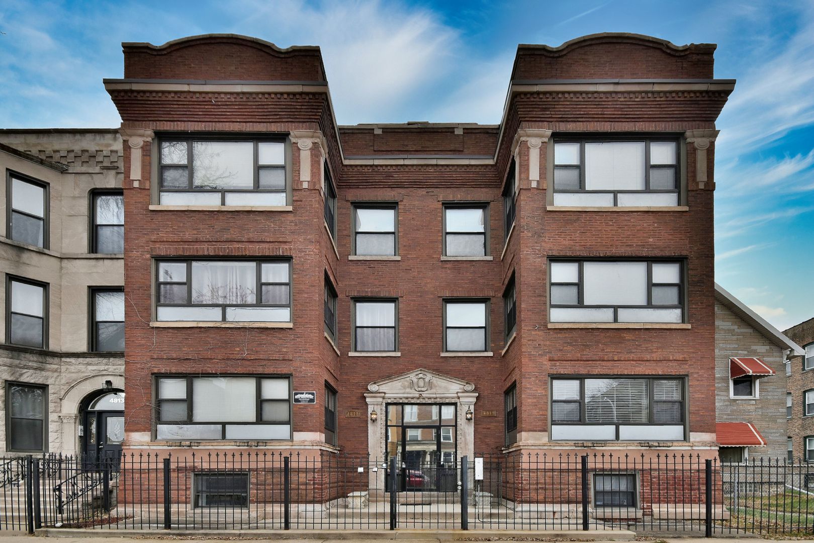 a front view of a residential apartment building with a yard