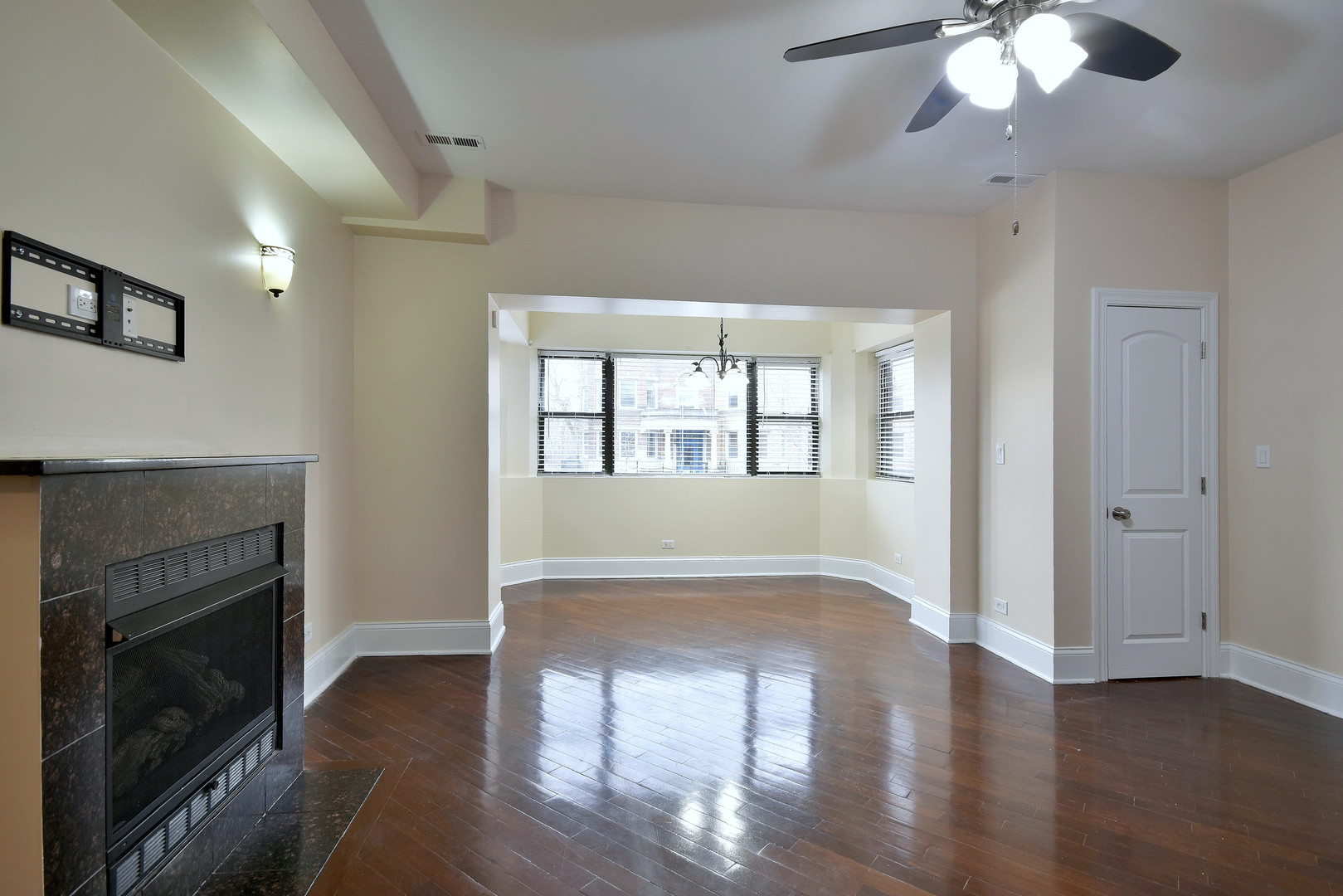 4819 South Prairie Avenue, Unit 1 Chicago, IL 60615 - Photo 5 of 16 a view of an empty room with wooden floor fireplace and a window