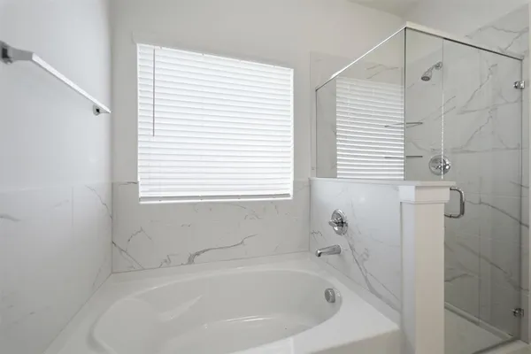 a white bath tub sitting next to a white sink and vanity