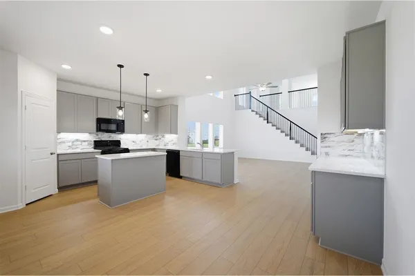a kitchen with stainless steel appliances kitchen island a sink a stove a refrigerator and cabinets