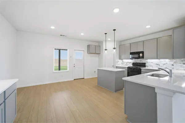 a kitchen with kitchen island a sink stainless steel appliances and window