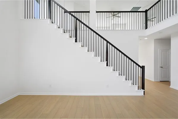 a view of staircase with wooden floor and white walls
