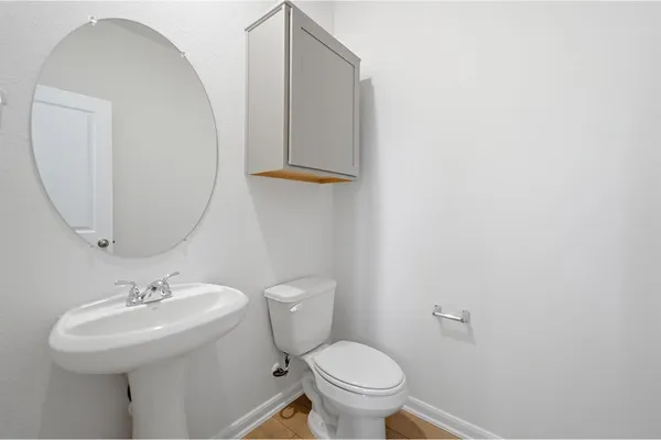 a bathroom with a sink a toilet and mirror