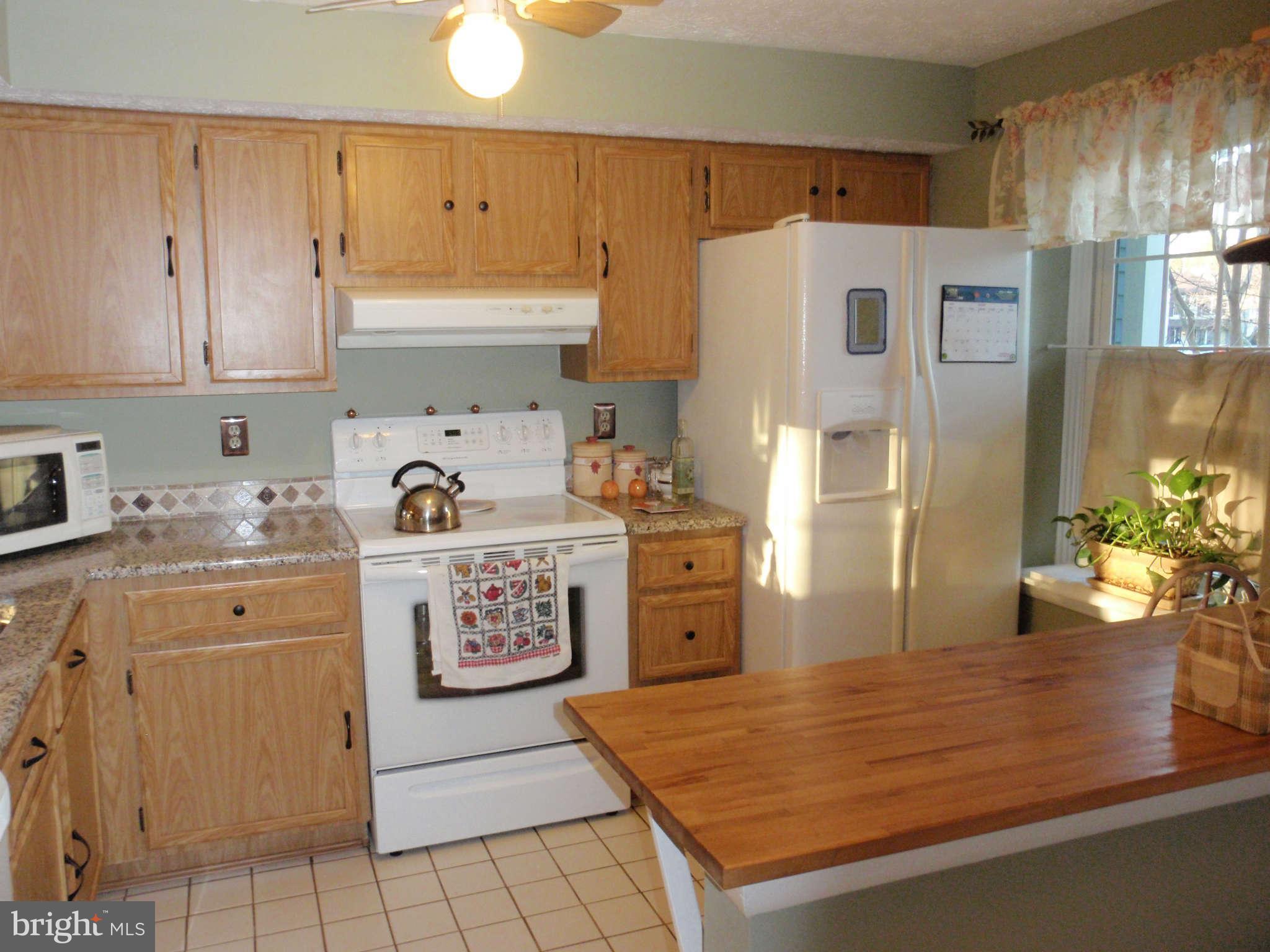 12139 Purple Sage Court Reston, VA 20194 - Photo 5 of 21 a kitchen with stainless steel appliances a refrigerator sink and cabinets