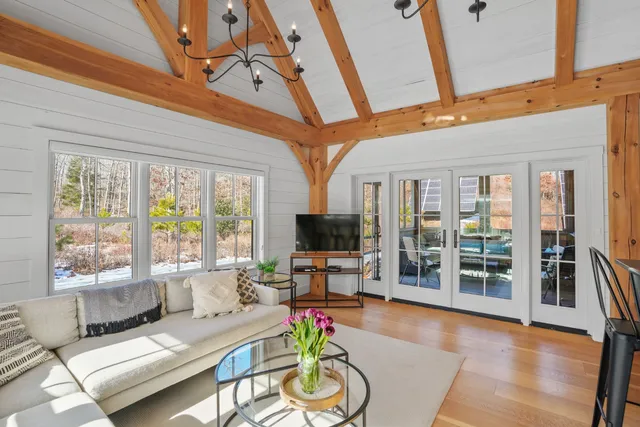 a living room with furniture a flat screen tv and a floor to ceiling window