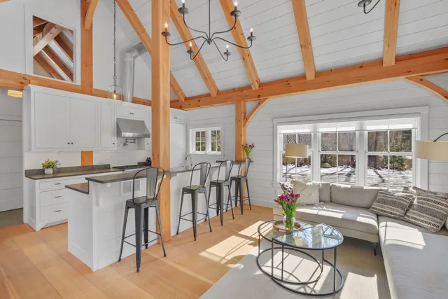 a living room with furniture a rug and kitchen view