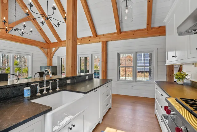 a kitchen with stainless steel appliances granite countertop a sink a stove and a wooden floors