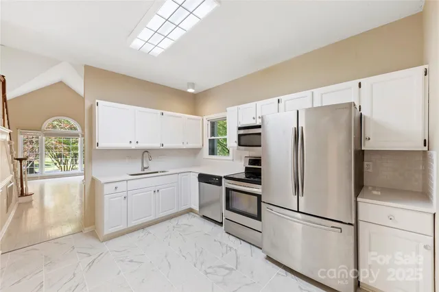 a kitchen with stainless steel appliances a refrigerator sink and stove