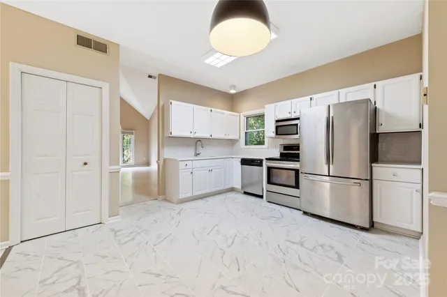 a kitchen with stainless steel appliances a refrigerator sink and cabinets