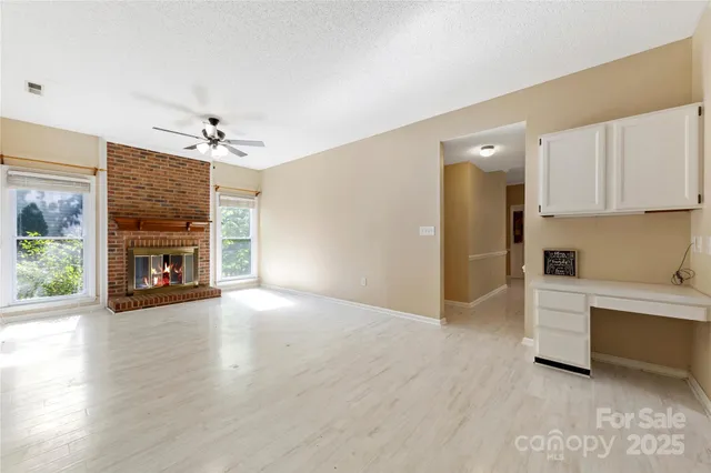 a view of an empty room with a fireplace and a window