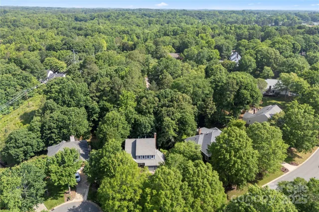 a view of a house with a street and trees