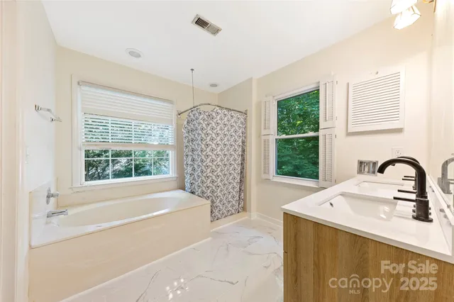 a bathroom with a bathtub sink and window