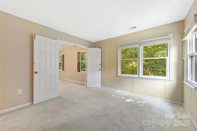 an empty room with windows and closet