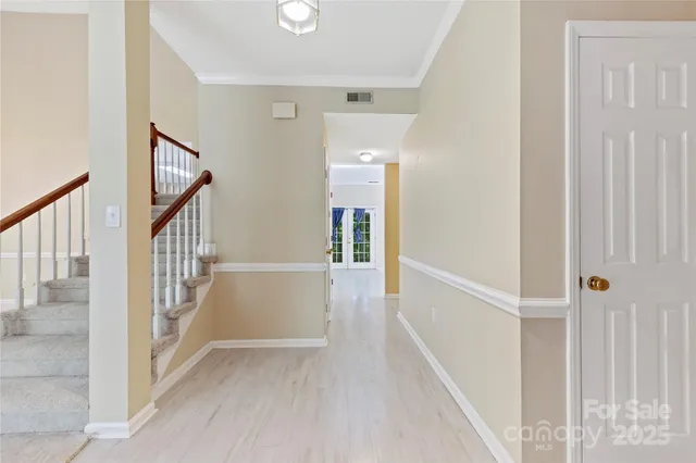 a view of a hallway with wooden floor and staircase