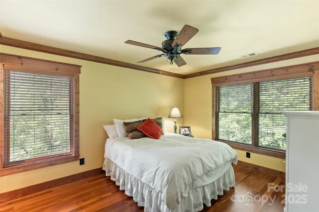 a bed sitting in a spacious bedroom next to a window