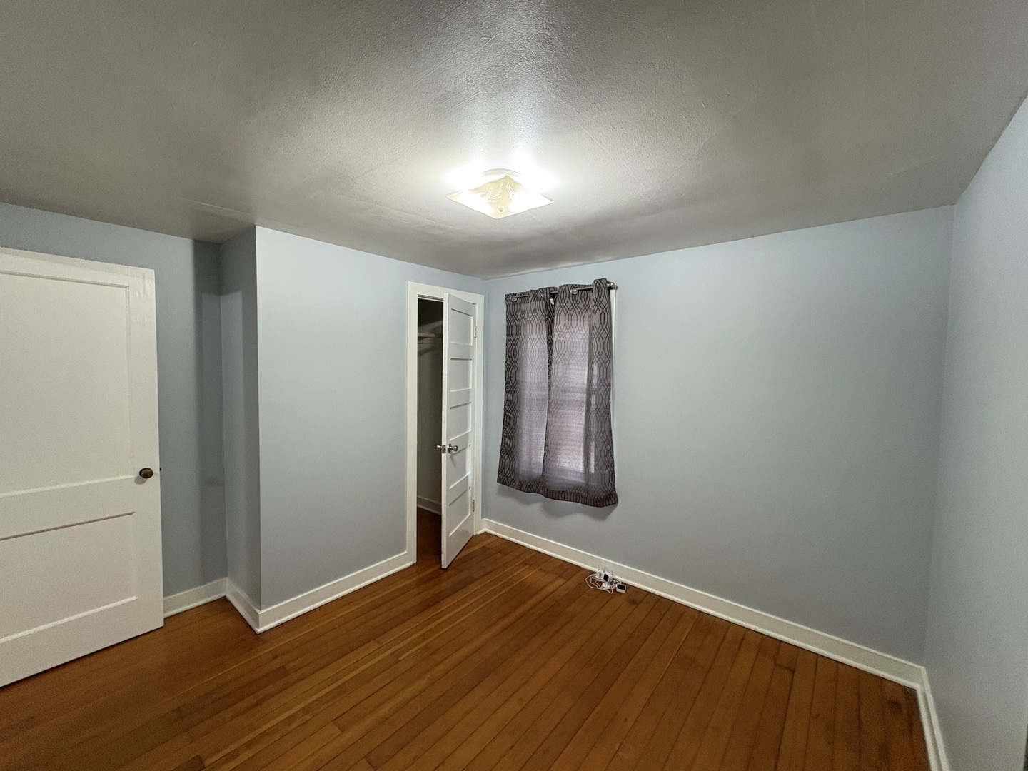 9758 East Flagg Road Rochelle, IL 61068 - Photo 11 of 22 an empty room with wooden floor and windows
